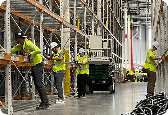 Workers cleaning pallet racking